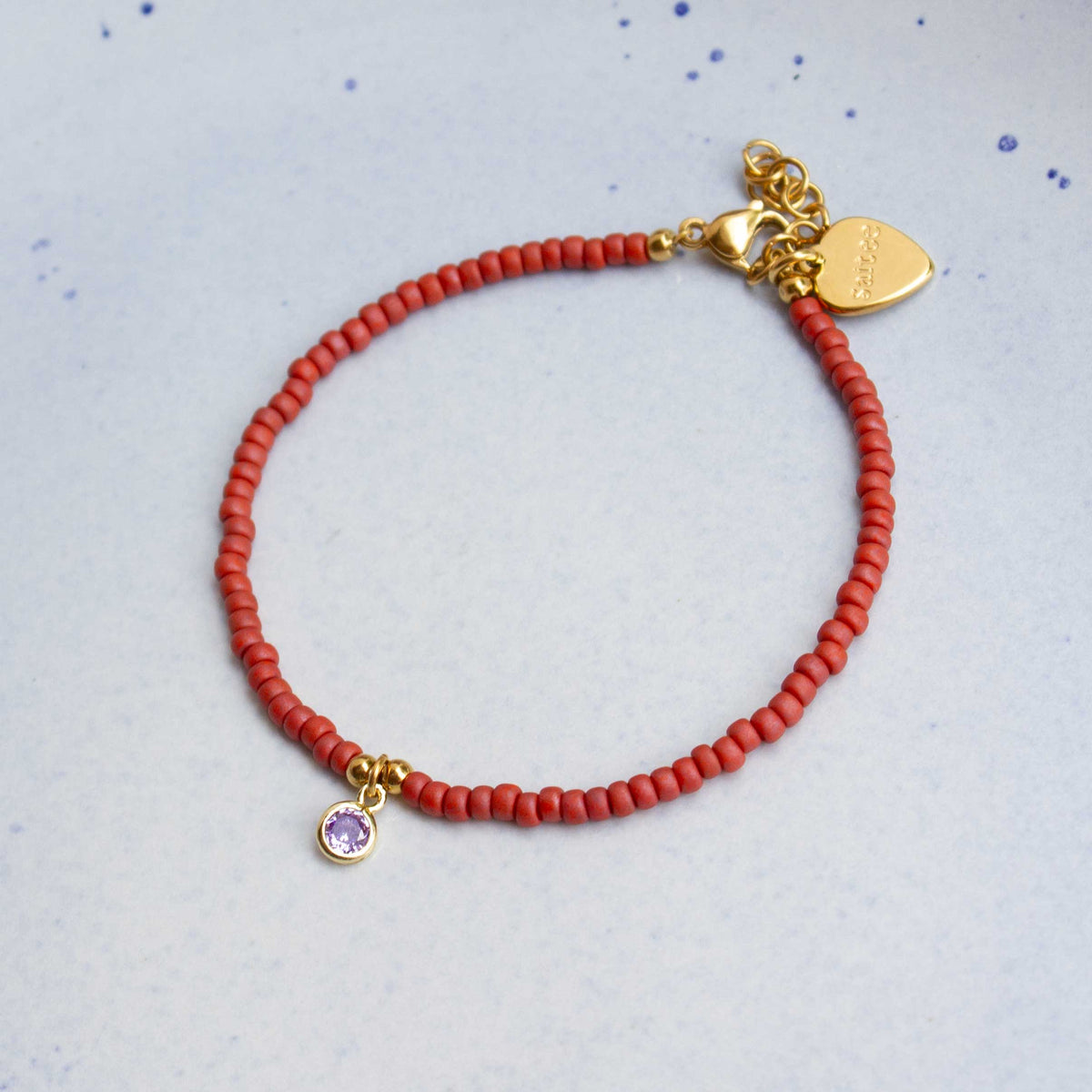 close up terra rood armbandje met bedel