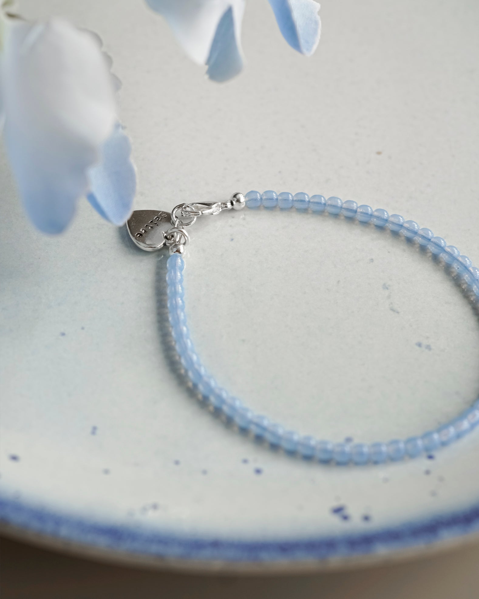 lichtblauw kralenarmbandje met hartjesbedel