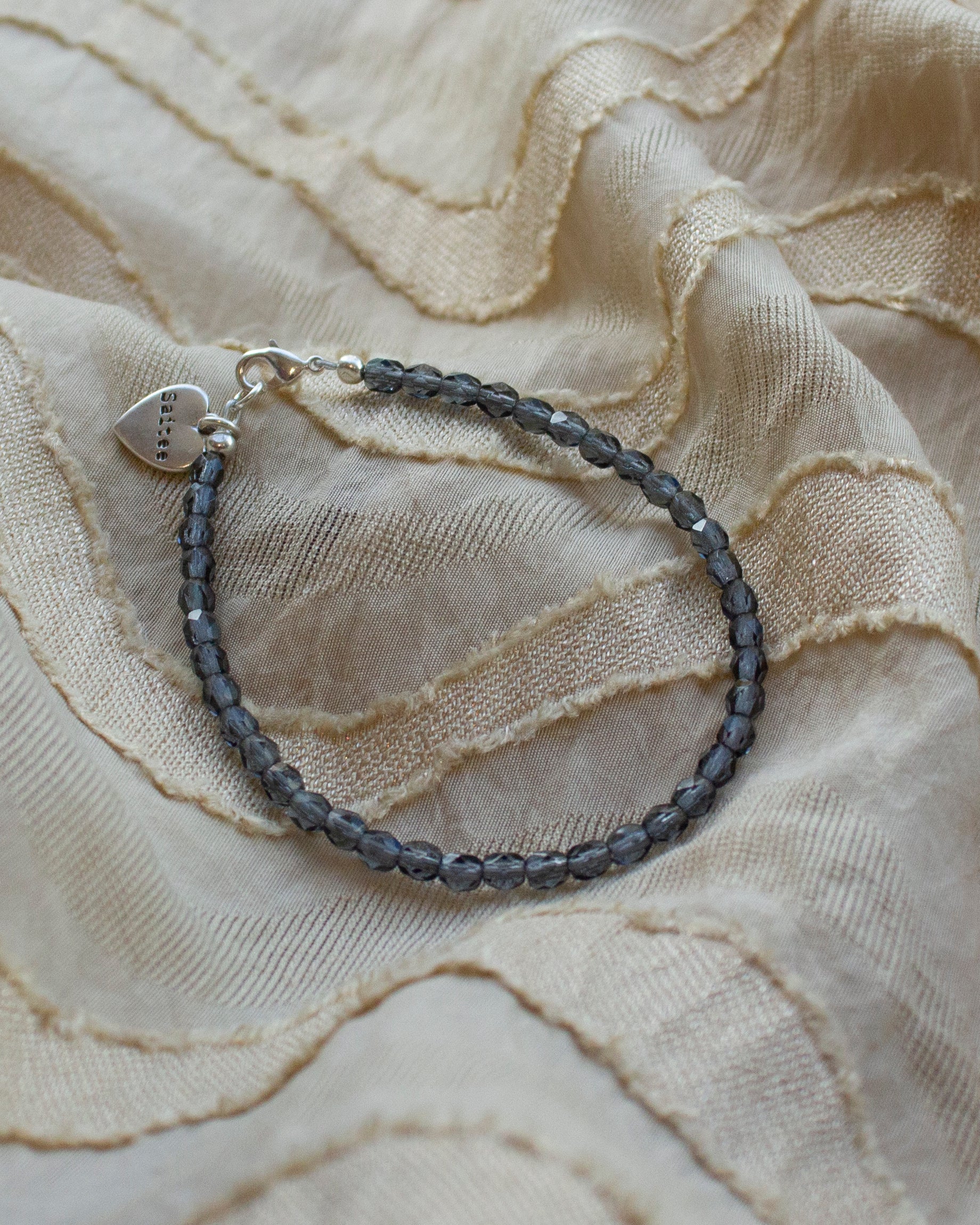 denimblauw kralenarmbandje met hartjesbedel