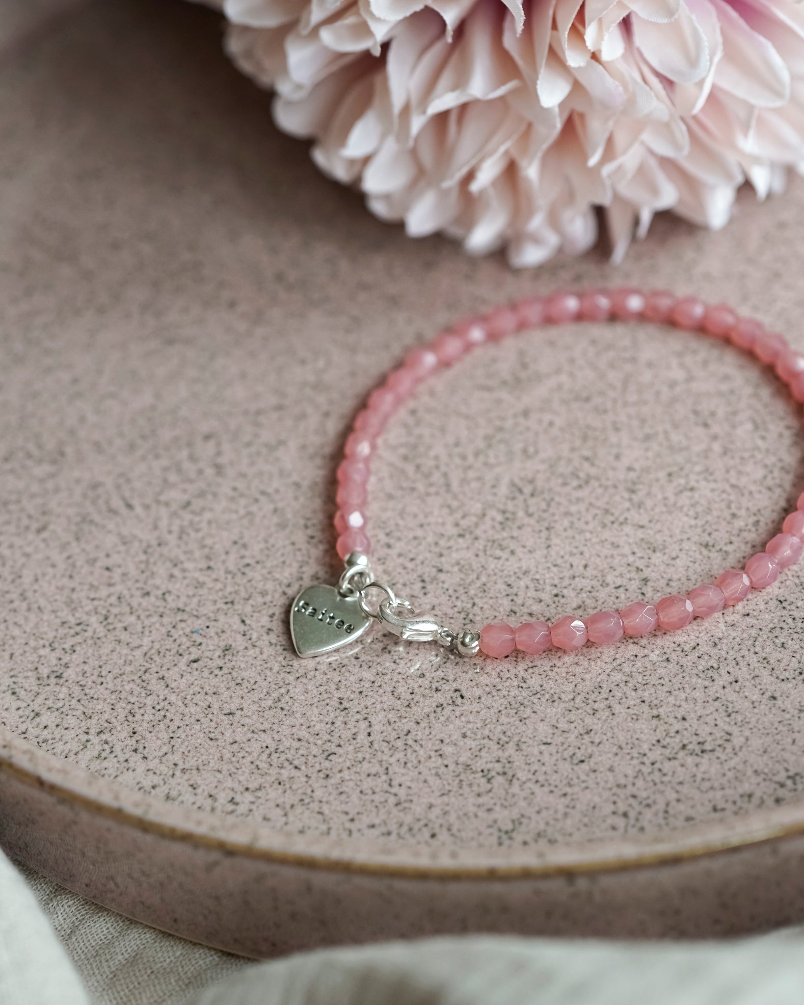 oranje roze kralenarmbandje met hartjesbedel