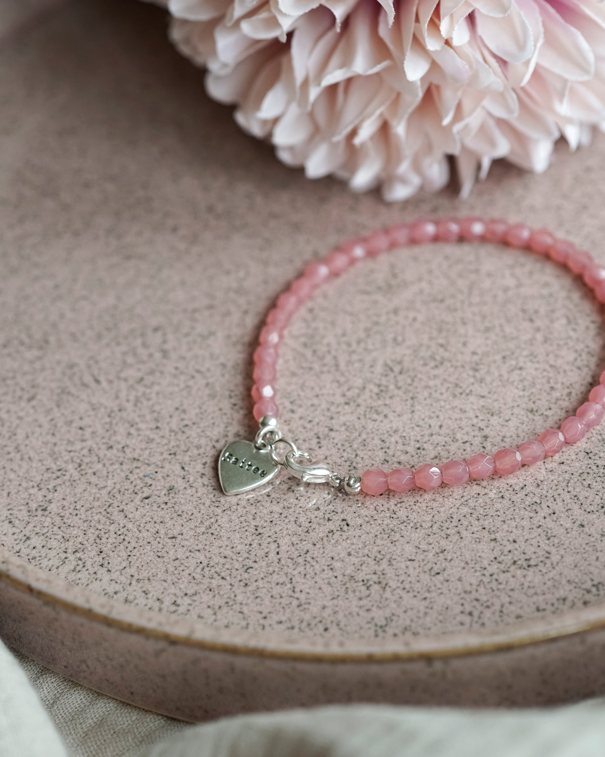 oranje roze kralenarmbandje met hartjesbedel