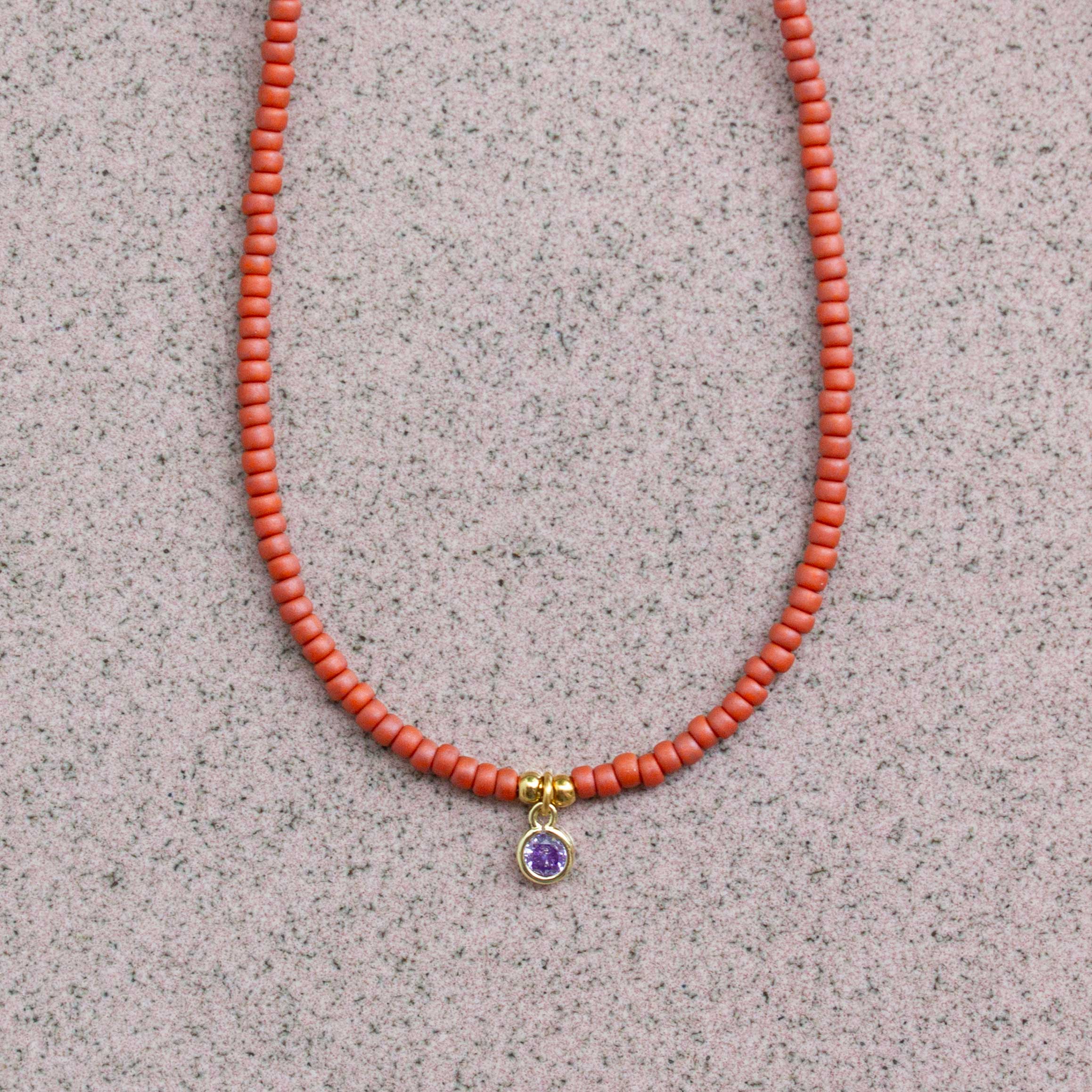 close up terra rood kettinkje met hanger