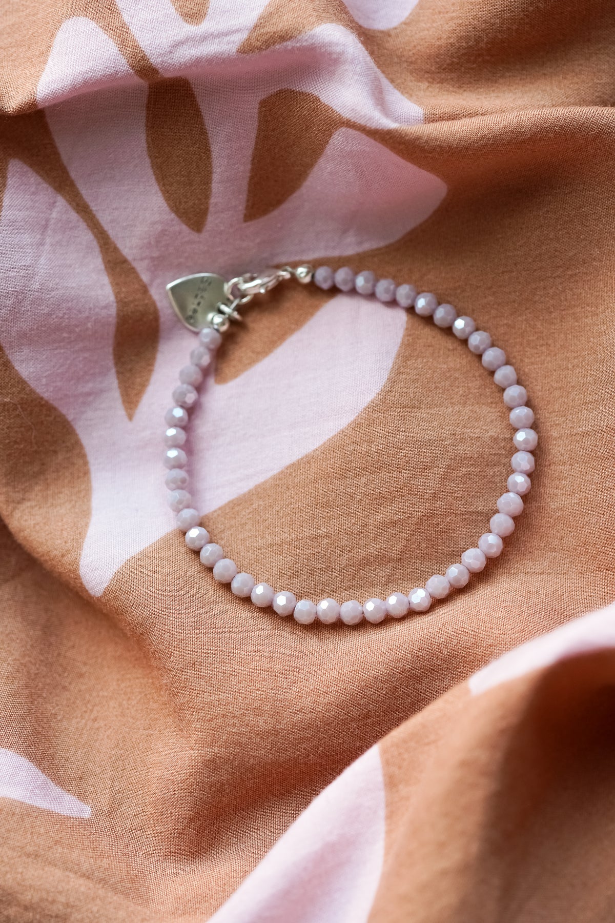 lila glimmend kralenarmbandje met hartjes bedel