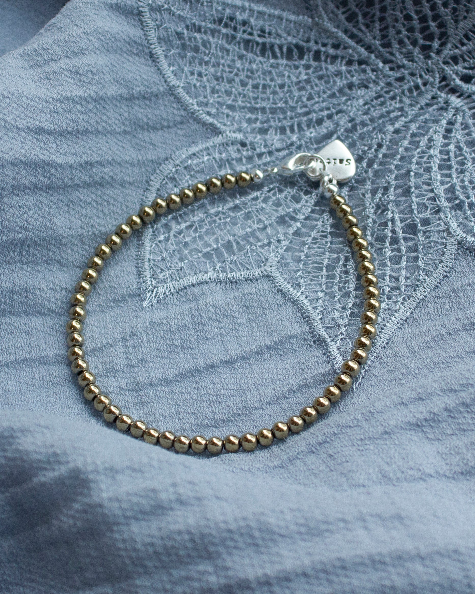 goud glanzend kralenarmbandje met hartjesbedel