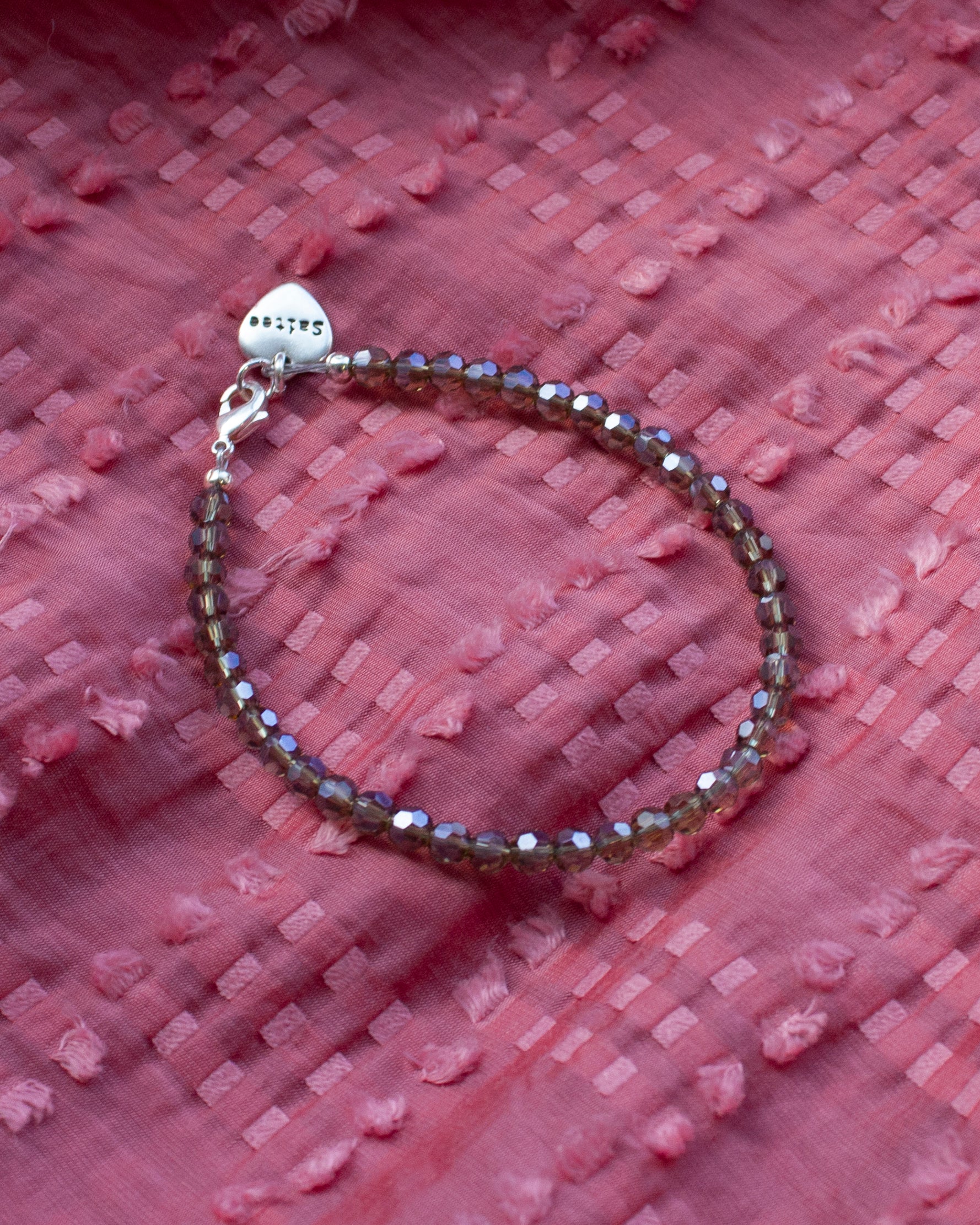 glanzend grijsbruin kralenarmbandje met hartjesbedel