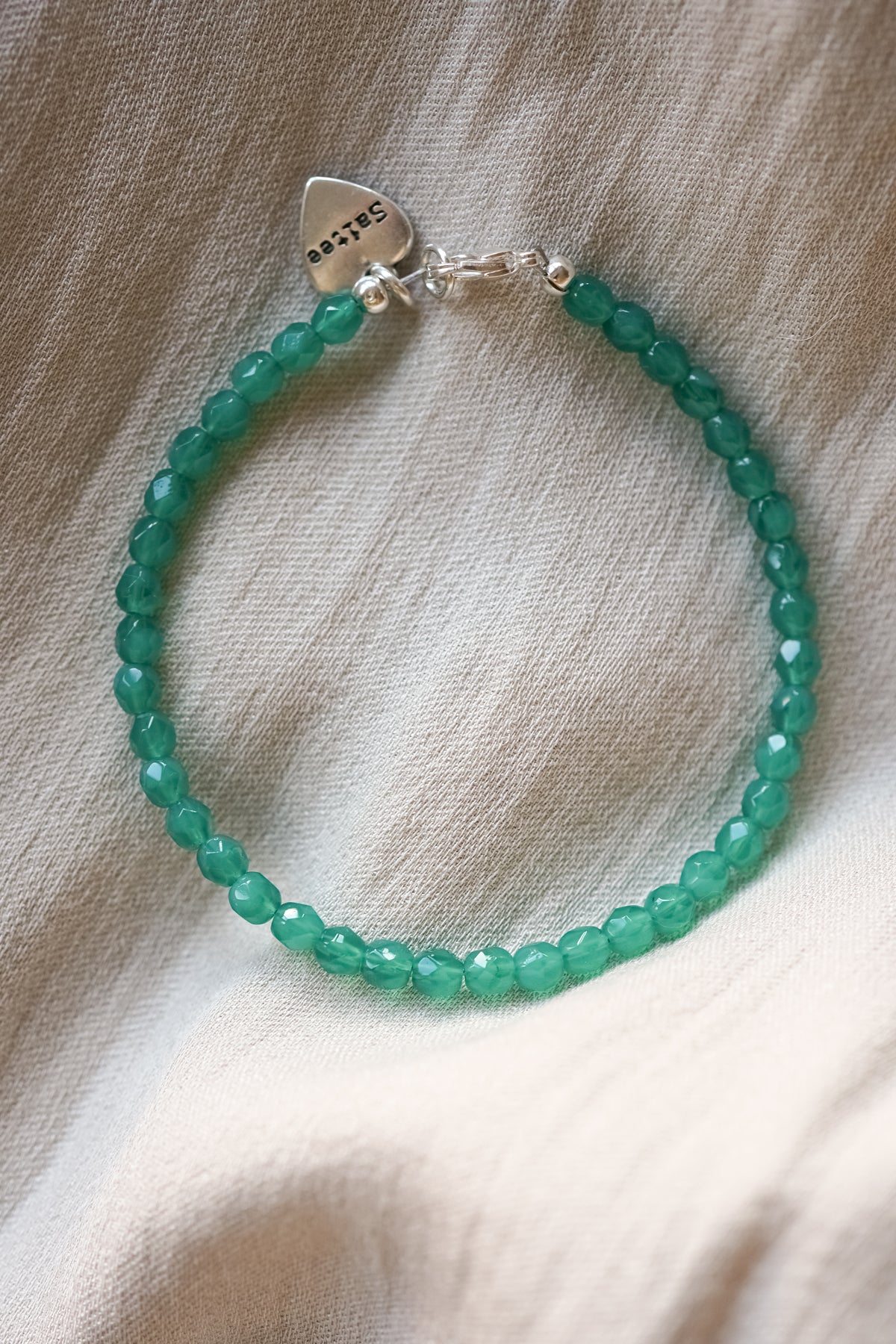 knalgroen kralenarmbandje met hartjes bedel