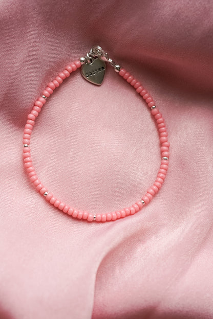 oranjeroze kralenarmbandje met hartjesbedel