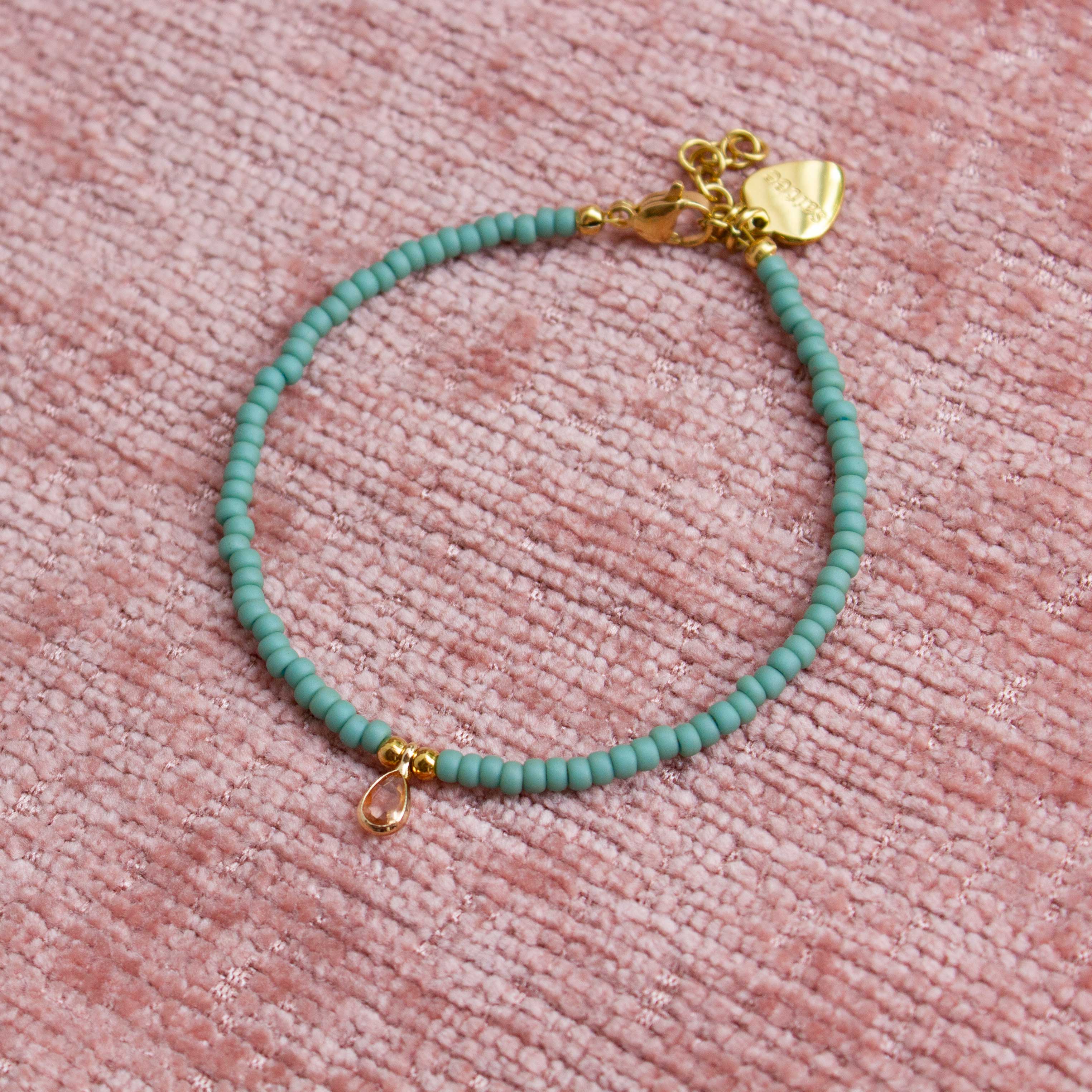 close up mintgroen armbandje met bedel 