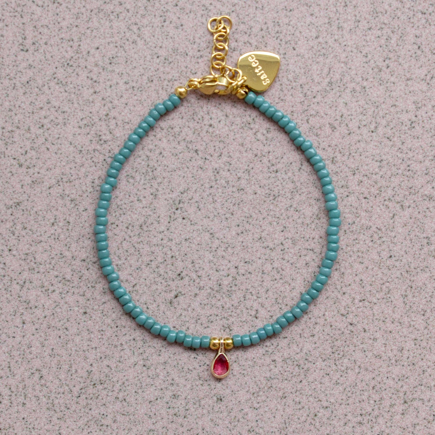 close up petrolgroen armbandje met bedel