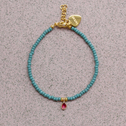 close up petrolgroen armbandje met bedel