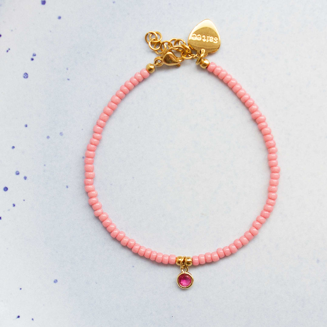 close up roze armbandje met bedel