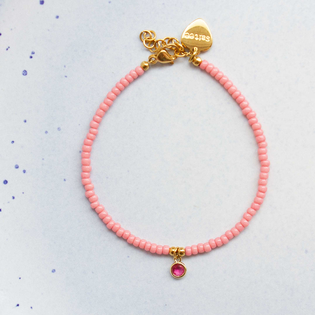 close up roze armbandje met bedel