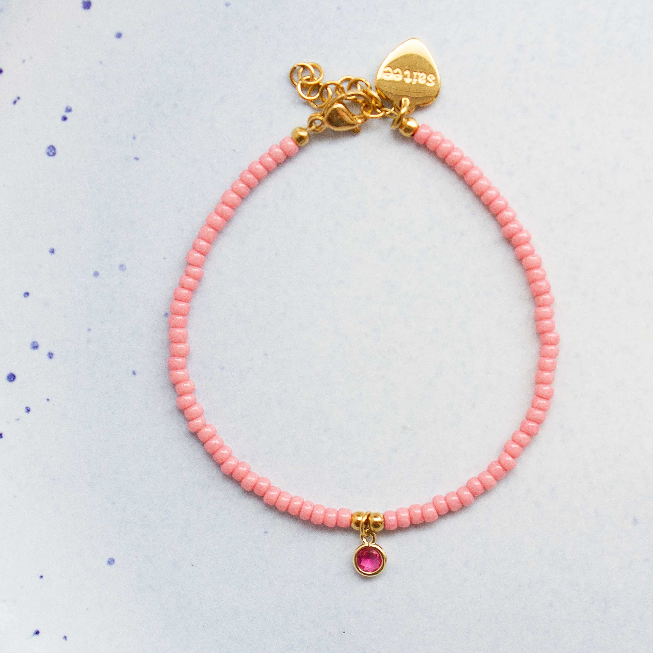 close up roze armbandje met bedel