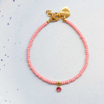 close up roze armbandje met bedel