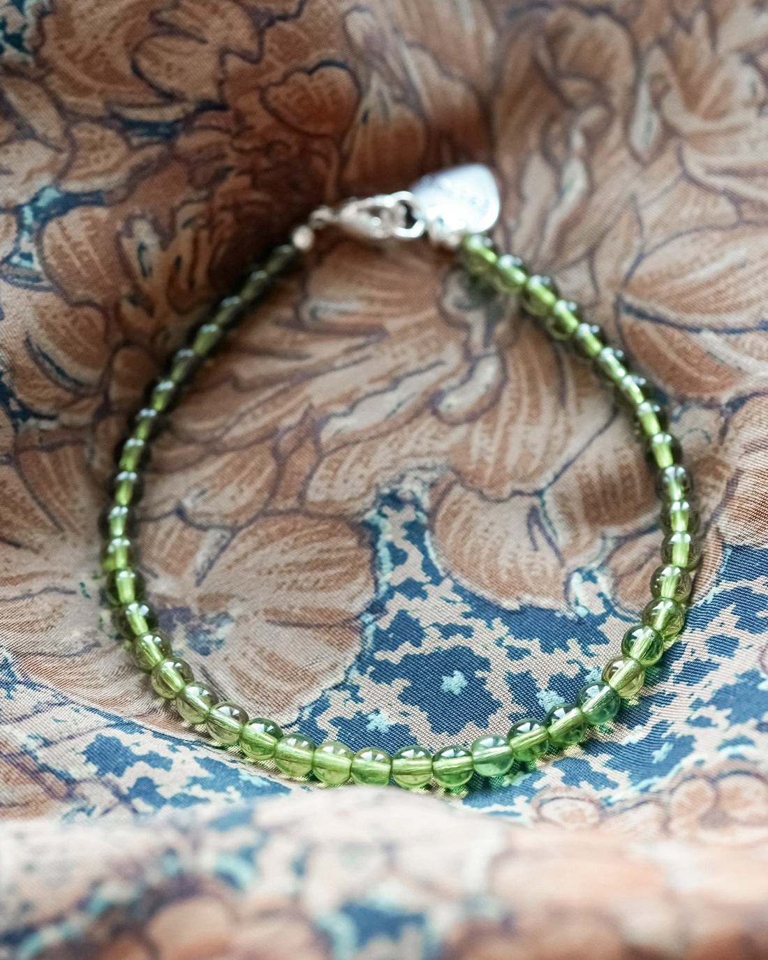 olijfgroen kralenarmbandje met hartjesbedel