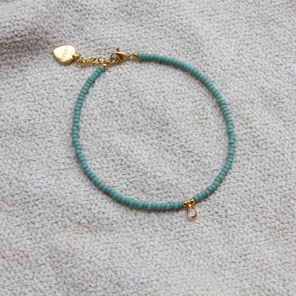 close up mintgroen enkelbandje met bedel 
