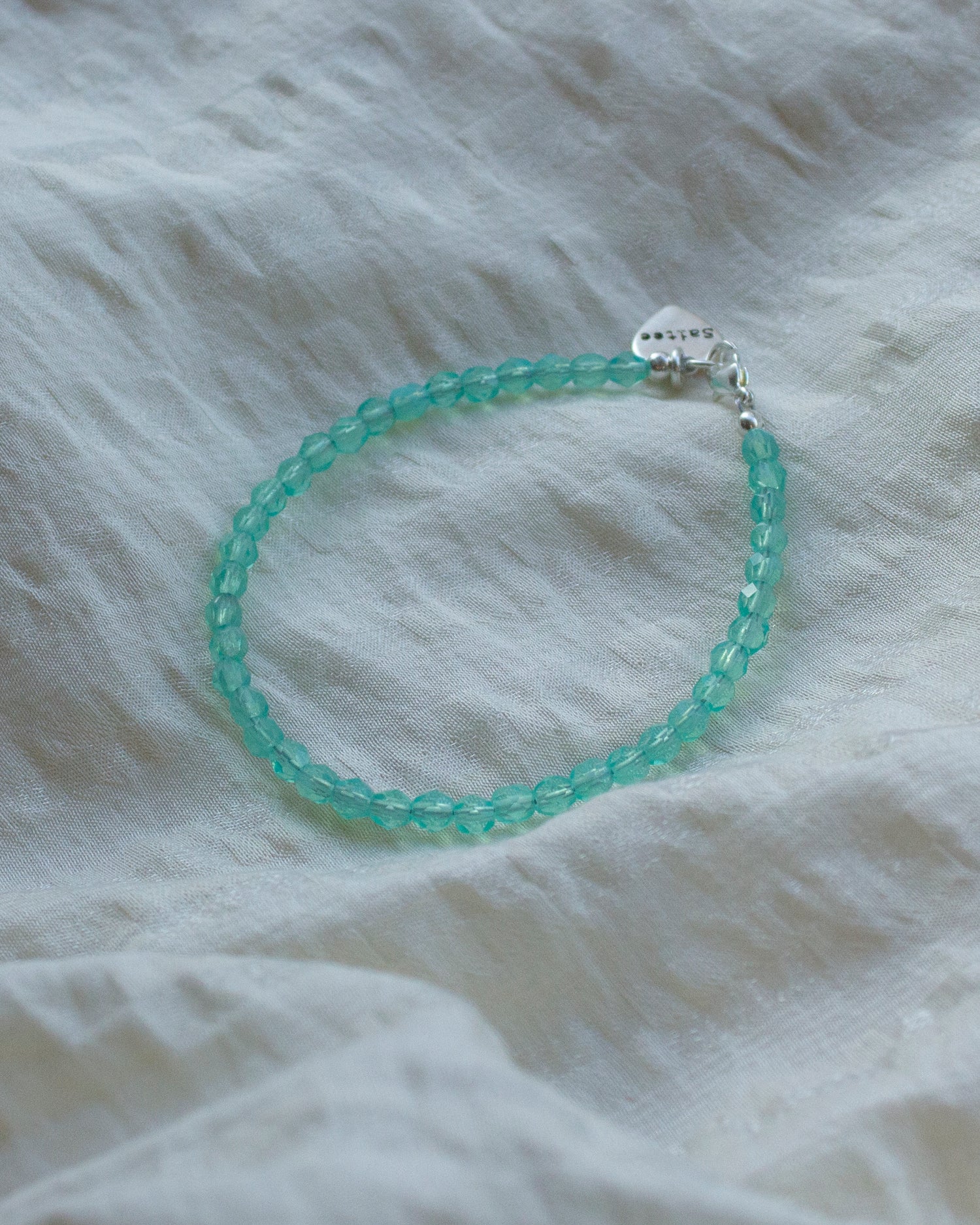 aqua kralenarmbandje met hartjesbedel