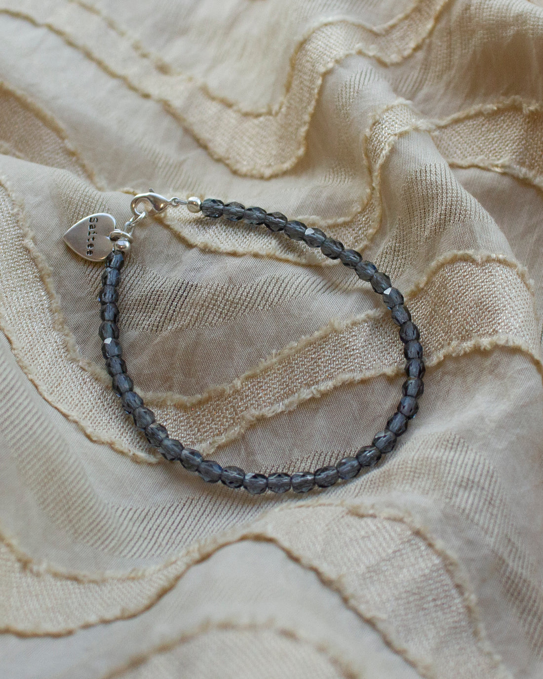 denimblauw kralenarmbandje met hartjesbedel