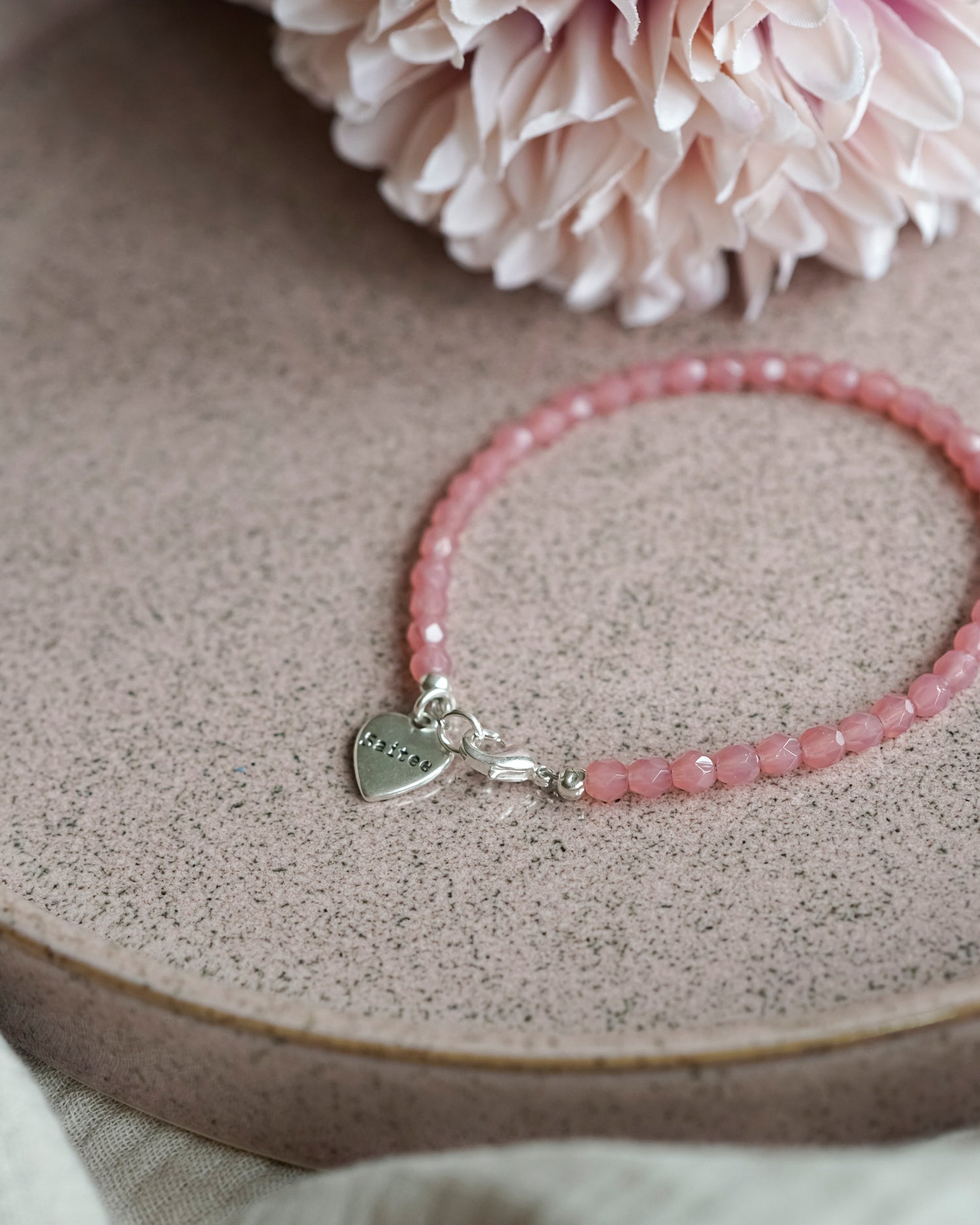 oranje roze kralenarmbandje met hartjesbedel