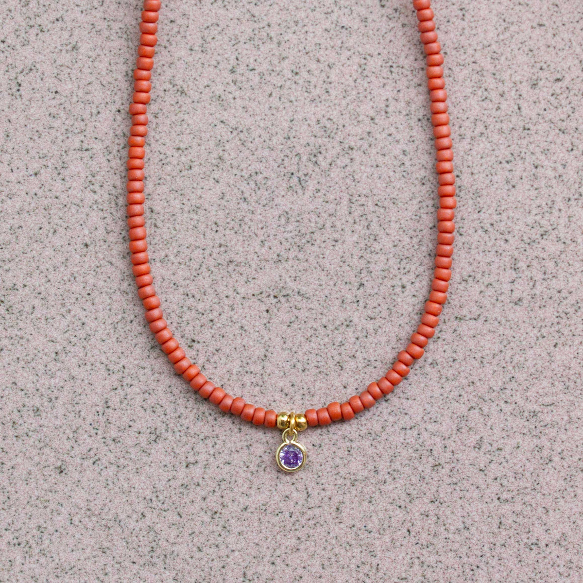 close up terra rood kettinkje met hanger