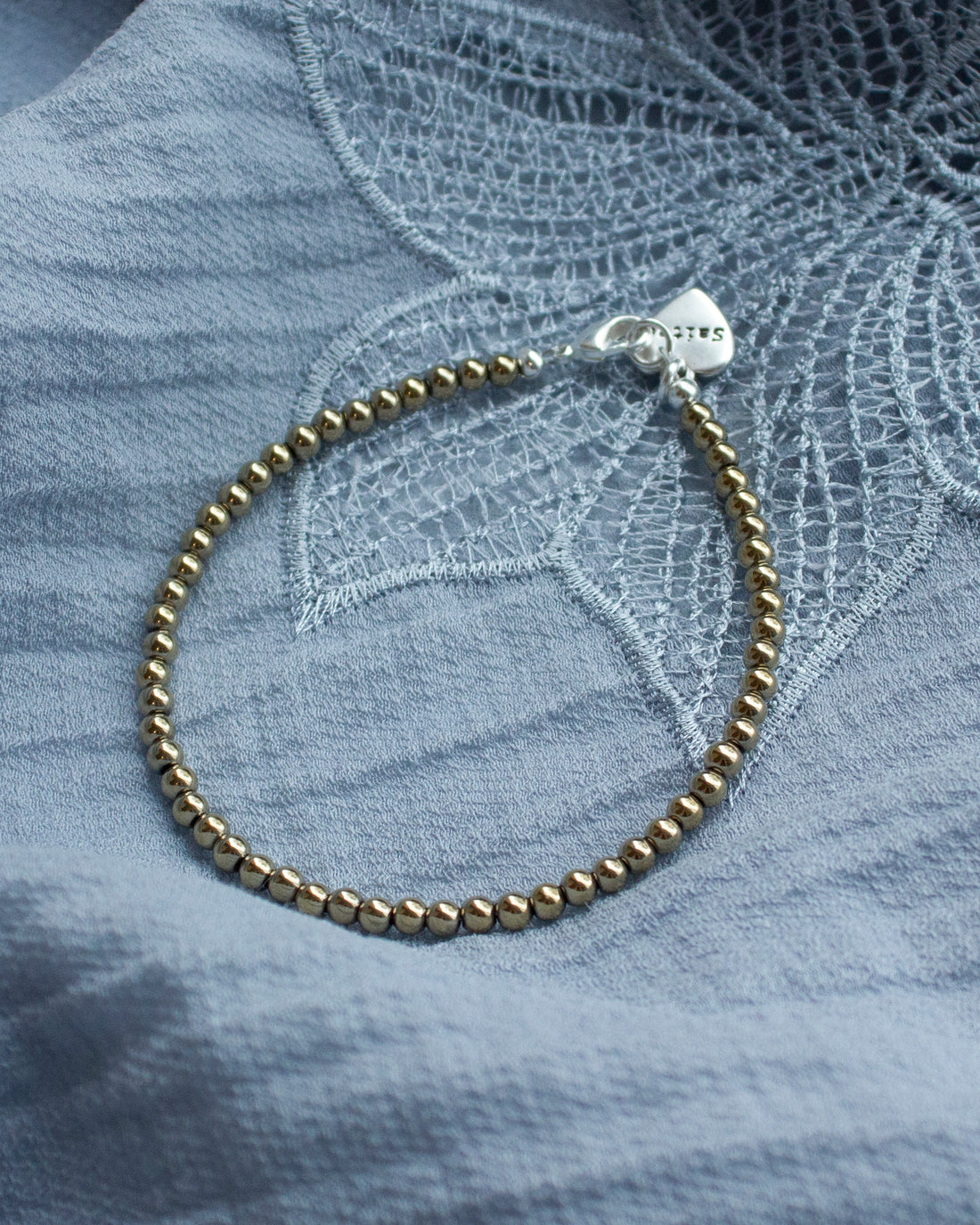 goud glanzend kralenarmbandje met hartjesbedel