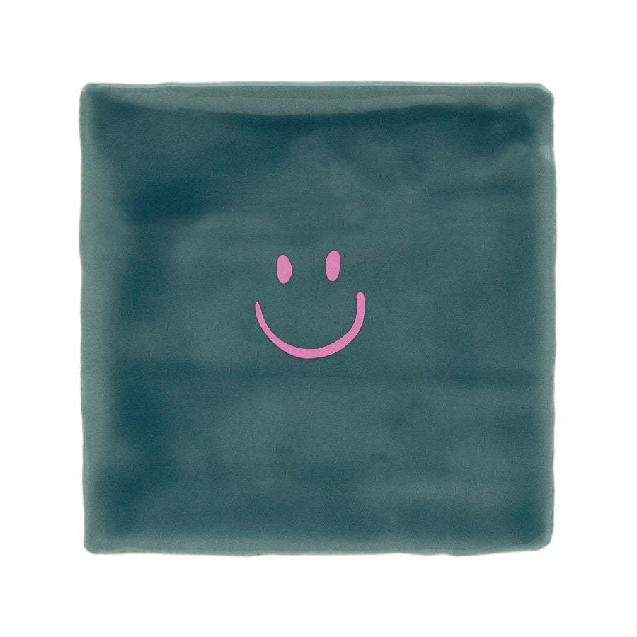 petrol groene tegel met roze smiley