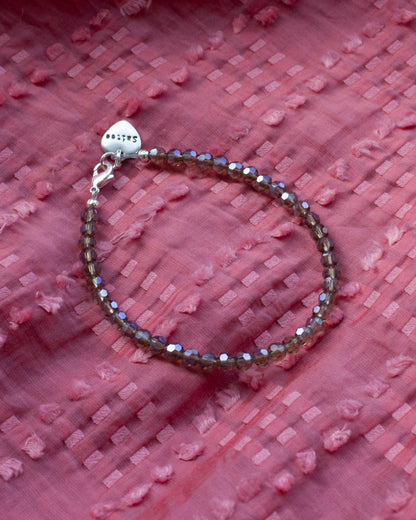 glanzend grijsbruin kralenarmbandje met hartjesbedel