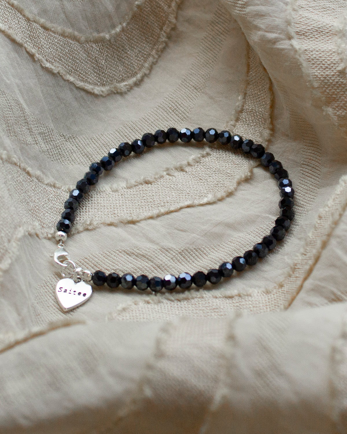 donkerblauw glimmend kralenarmbandje met hartjes bedel