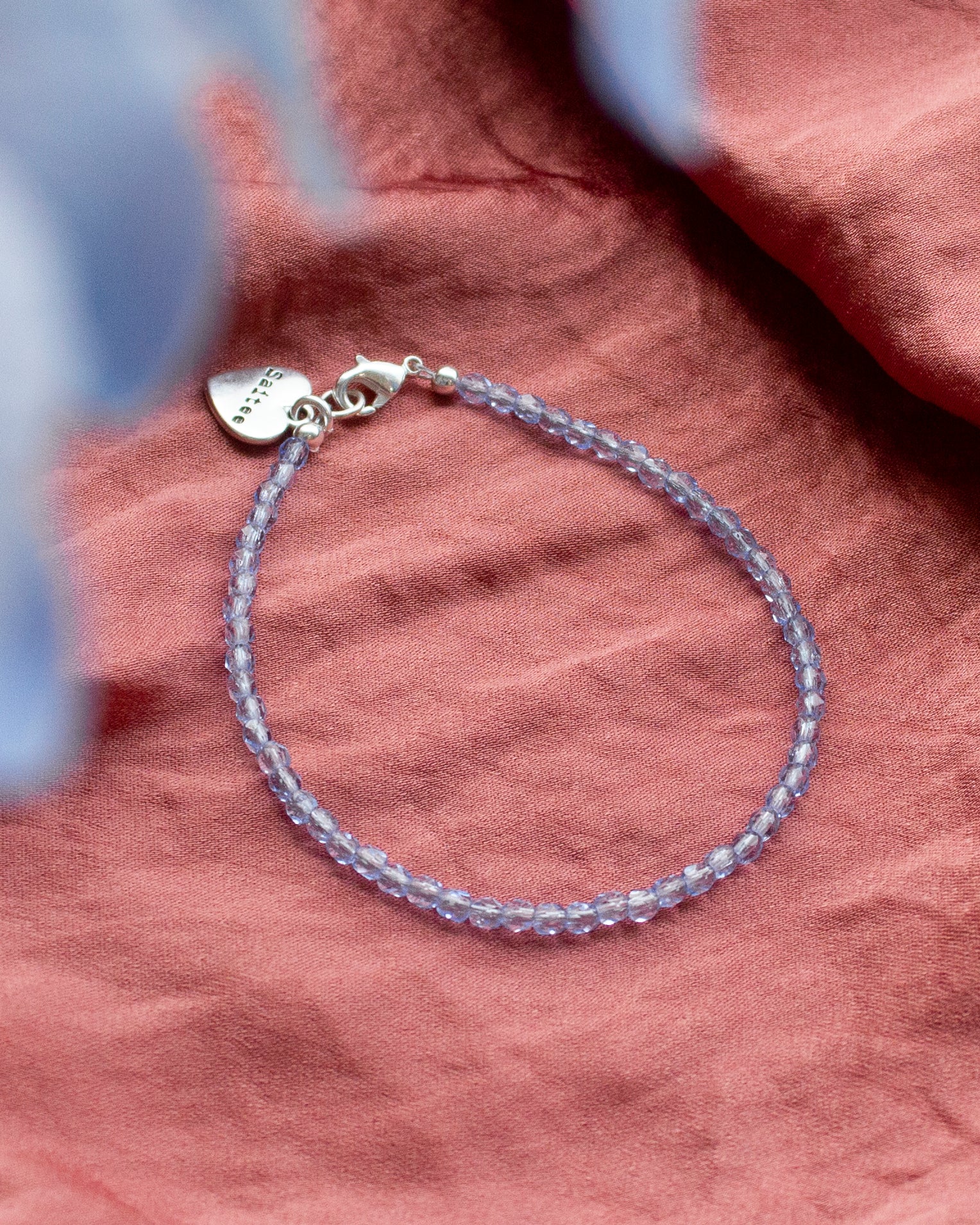 lichtblauw kralenarmbandje met hartjesbedel