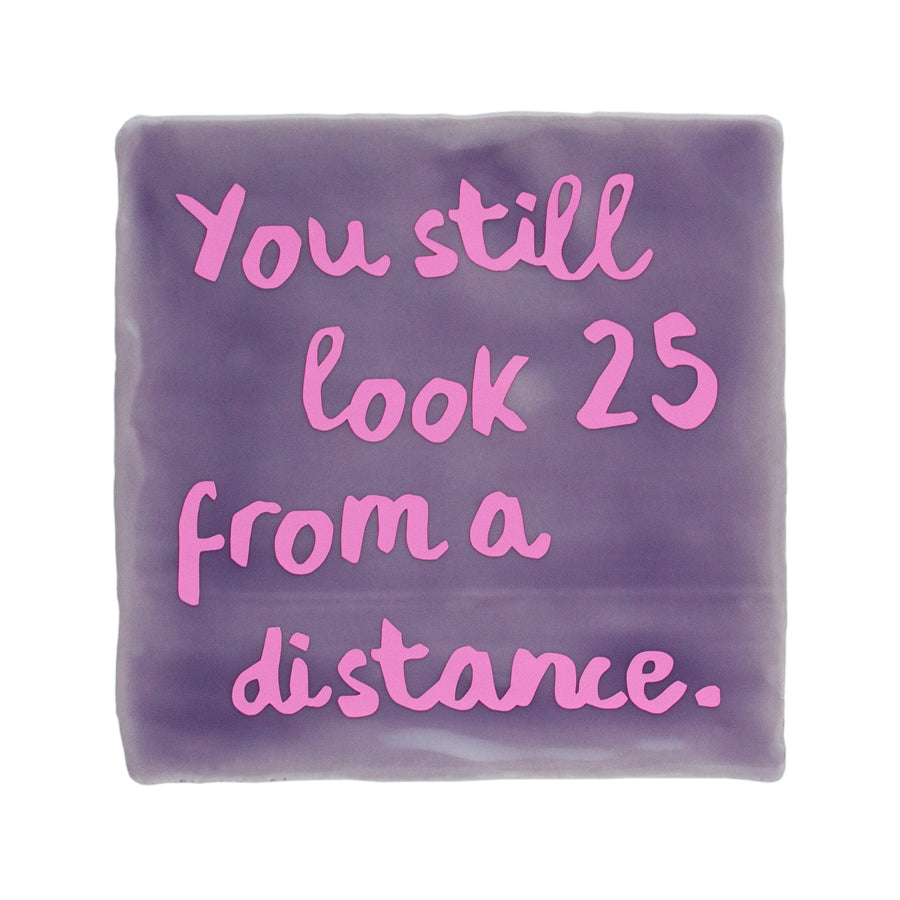 lila tegel met roze tekst you still look 25 from a distance